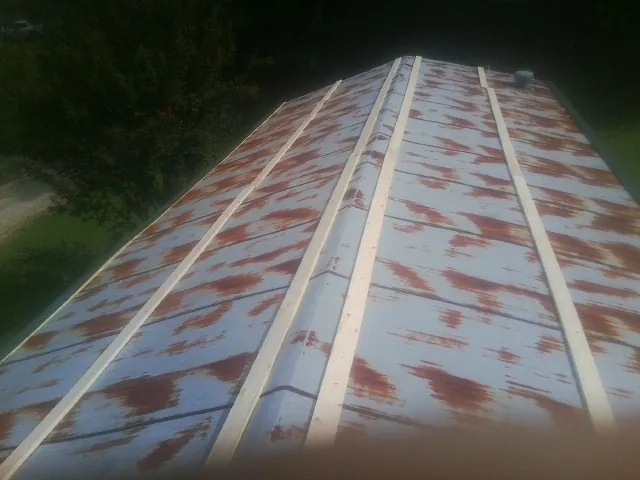 Rusted metal roof panels with new wood purlins before replacement — Storm Damage Roof Repair in Garretson by Roofing Brothers