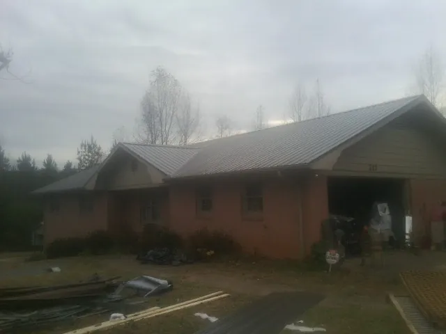 Gray metal roof on a stucco house with an attached garage in Garretson