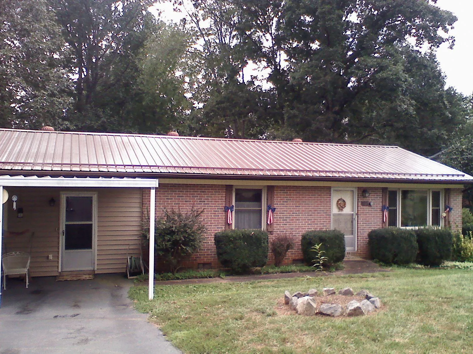 Bronze metal roof and carport on a brick ranch home — Roof Repair work by our crew in Garretson